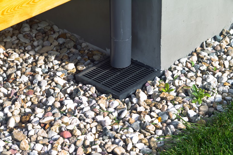 rainwater-downspout-with-pebbles-and-grill